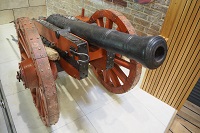 A replica 17th century cannon with red wheels